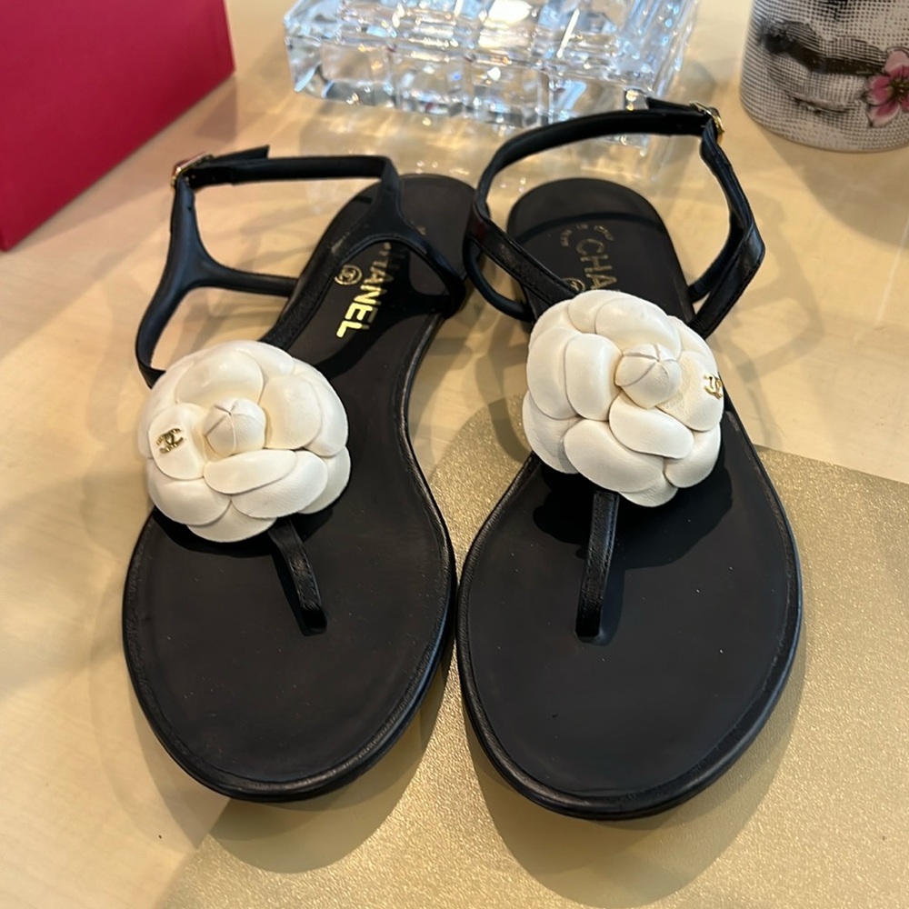 Chanel black leather sandal.  White flower and gold cc detail.